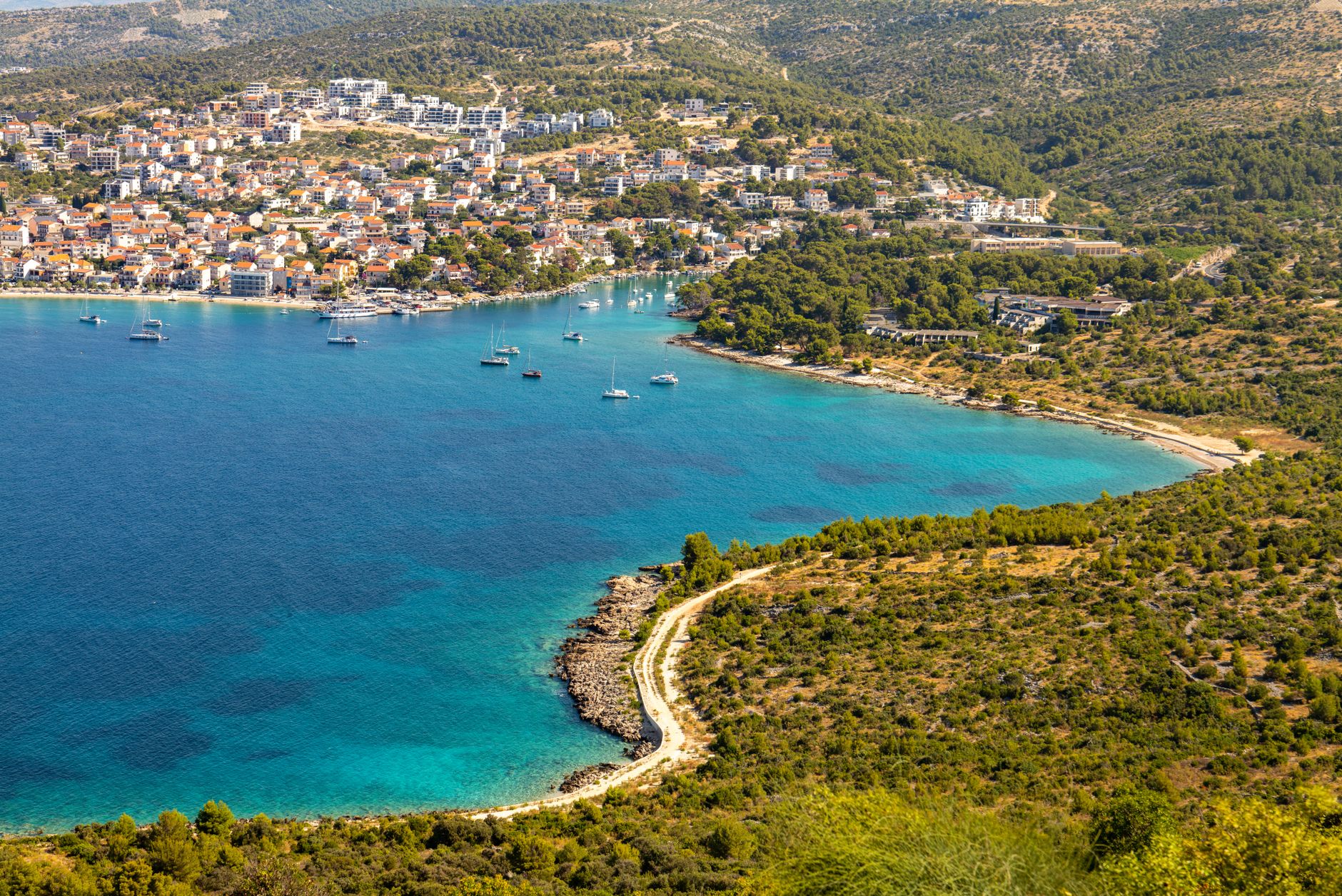 A stunning aerial view of Primošten's coastline, showcasing its turquoise waters and lush greenery.