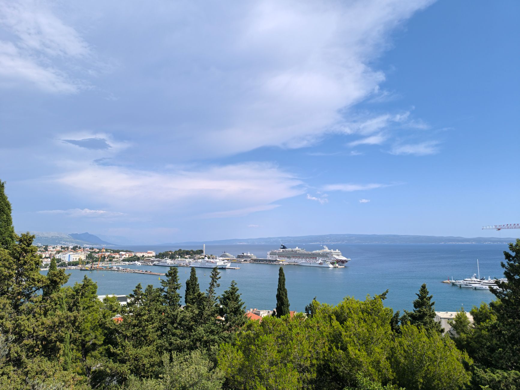 Beautiful panoramic view of Split harbor, Croatia, with cruise ships and lush greenery.