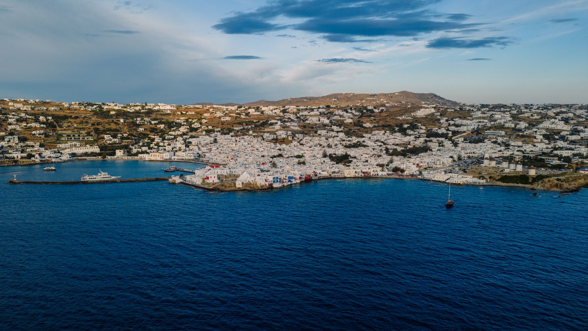 Scenic aerial view of Mykonos Island, Greece, showcasing traditional white buildings and vibrant blue sea.