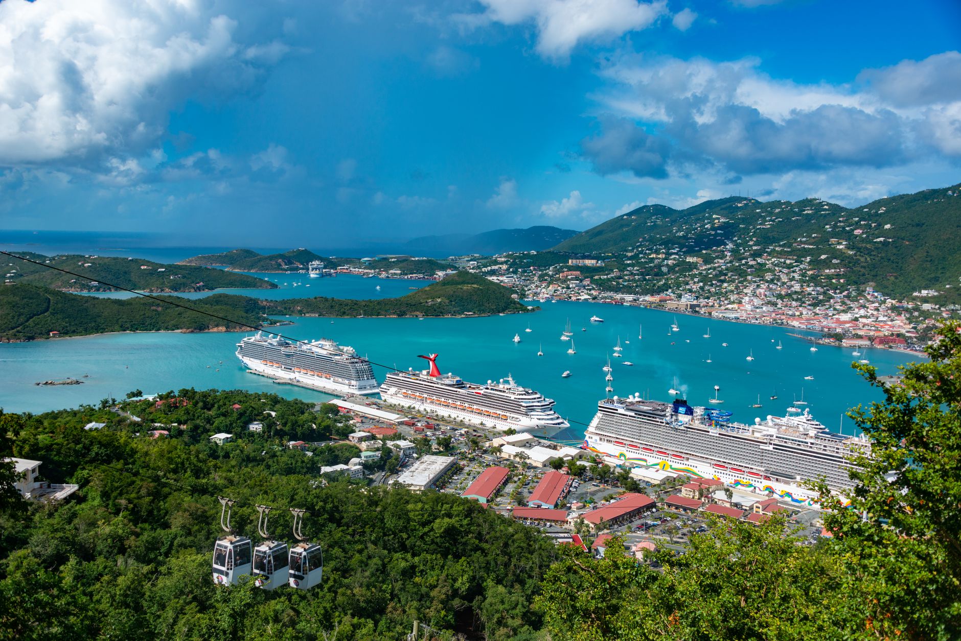 Aerial view of cruise ships docked in Charlotte Amalie Bay, Virgin Islands, under blue skies.